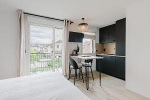 a kitchen with a table and chairs and a balcony at Appart Hotel Neostelia in Annecy