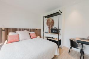 a bedroom with a bed and a desk with a computer at Appart Hotel Neostelia in Annecy