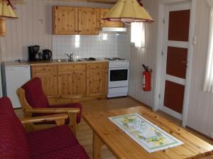a kitchen with a table and chairs and a stove at Maråk Hytteutleige in Geiranger