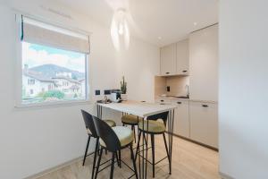 a kitchen with a table and chairs and a window at Appart Hotel Neostelia in Annecy