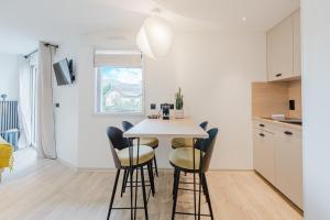 a kitchen and dining room with a table and chairs at Appart Hotel Neostelia in Annecy