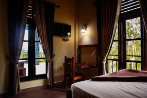 een slaapkamer met 2 grote ramen en een bed bij The Hidden Heaven in Diyatalawa