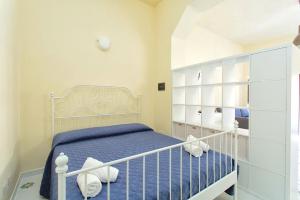 a bedroom with a white bed with blue sheets at Il Veliero Blu Suite Lipari Centro - Corso Vittorio Emanuele in Lipari