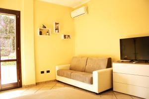 sala de estar con silla y TV de pantalla plana en Villa Elizabeth Bilocale, en Gallipoli