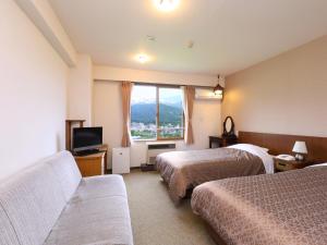 Postel nebo postele na pokoji v ubytování Hakuba Highland Hotel