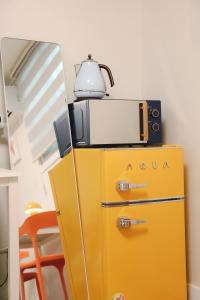 a yellow refrigerator with a microwave on top of it at Hotel INSAENG Bucheon in Bucheon