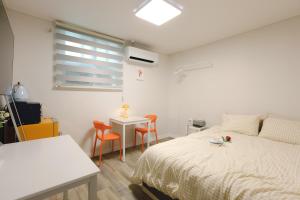富川市Hotel INSAENG Bucheon的一间卧室,里面有一张床、一张桌子和几把椅子。
