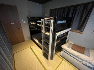 a small room with a bunk bed with a closet at Sakae Guesthouse in Nagoya