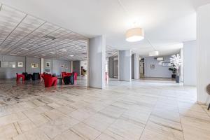 eine leere Lobby mit roten Stühlen und Tischen in der Unterkunft salgado`s nest in Portimão