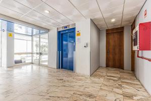 ein Büroflur mit blauen Türen und Fliesenböden in der Unterkunft salgado`s nest in Portimão