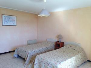 a bedroom with two beds and a lamp at Camping de l'Eouviere in Montmeyan