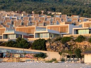 a building on a hill next to the water at Palase Green Coast 2 bedroom house in Himare