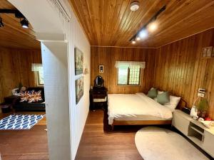 a bedroom with a bed in a room with wooden walls at 阿喜紫藤 in Meishan