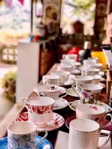 a row of cups and saucers on a table at 阿喜紫藤 in Meishan
