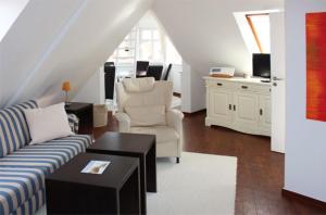 ein Wohnzimmer mit einem Sofa, Stühlen und einem Tisch in der Unterkunft Inselresidenz Strandburg - Ferienwohnung 305 (Ref. 50973) in Juist