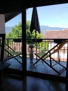 a view of a porch with a chair and an umbrella at Apartman Aldina in Bihać