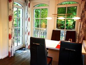 a dining room with a table and chairs and windows at Haus Meeresblick - Ferienwohnung Sandrose A 2.26 (Ref. 132363) in Baabe