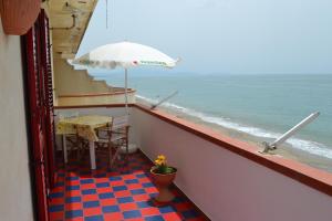 uma varanda com uma mesa e um guarda-sol e o oceano em casa vacanze dei navigatori on the sea em Pontecagnano