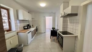 a kitchen with white appliances and a table in it at Zentrale 3 Zimmer Unterkunft mit Parkplatz in Neumünster