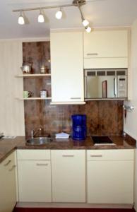 eine Küche mit weißen Schränken und einem Waschbecken in der Unterkunft Inselresidenz Strandburg Juist - Wohnung 107 (Ref. 52044) in Juist