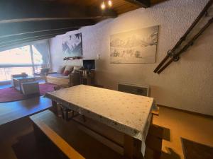 una sala de estar con una mesa y un sofá en Résidence Diamant 1 - Appartement atypique PLEIN CENTRE avec garage privatif et internet MAE-5271, en Les Deux Alpes 1 foto más
