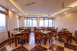 a restaurant with wooden tables and chairs and windows at Sumer Hotel in Sarahan