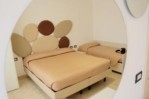 - 2 lits dans une chambre avec un miroir dans l'établissement Hotel Belvedere, à Sottomarina