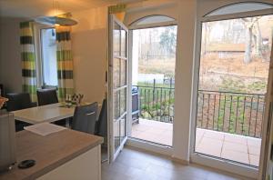 a kitchen with a sliding glass door leading to a balcony at Haus Meeresblick - Ferienwohnung Am Strand (Ref. 128682u1) in Baabe