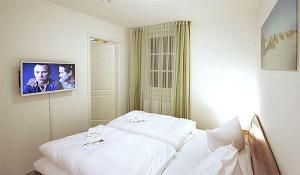 a white bed in a room with a picture on the wall at Haus Meeresblick - Ferienwohnung Am Strand (Ref. 128682u1) in Baabe +10 photos