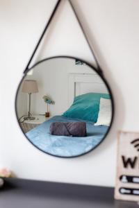 a mirror reflection of a bed in a bedroom at Le Léon 14 Joli studio avec balcon situé à Dieppe in Dieppe