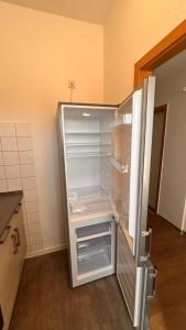 an empty refrigerator with its door open in a kitchen at Zentrale 3 Zimmer Unterkunft mit Parkplatz in Neumünster +45 photos
