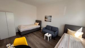 a room with a bed and a couch and a chair at Zentrale 3 Zimmer Unterkunft mit Parkplatz in Neumünster