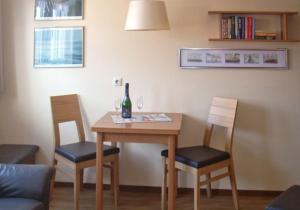 a dining room table with two chairs and a bottle of wine at Strandburg Juist - Apartment 301 (Ref. 50969) in Juist