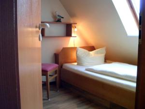 ein kleines Zimmer mit einem Bett und einem Stuhl in der Unterkunft Strandburg Juist - Apartment 301 (Ref. 50969) in Juist