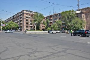 an empty street with cars parked in front of a building at Avenue Apart Hotel in Yerevan