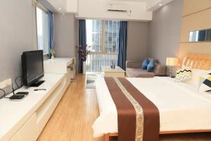 Una habitación de hotel con una cama grande y un televisor. en Jiayuan Executive ApartHotel Guangzhou Wuyangcun Metro Station Zhujiang New Town Branch, en Guangzhou