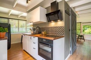 a kitchen with white cabinets and a stove top oven at Boshuisje Rekem - Silas in Lanaken +16 photos