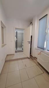 a white room with a door and a tile floor at Cosy House 400 m from Iulius Town in Timişoara