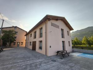 ein Gebäude mit einer Bank davor in der Unterkunft Apartamentos Villa de Panes - La Plaza in Panes