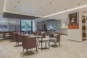 a restaurant with tables and chairs in a room at Akoya Business Hotel - Smart Stays, Whitefield in Whitefield