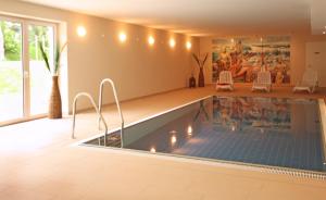 a swimming pool in a house with two chairs around it at Haus Meeresblick - Ferienwohnung Abendrot (Ref. 132364) in Baabe