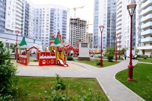 a playground in a park with tall buildings at Yin Yang in Moskva Complex in Yekaterinburg