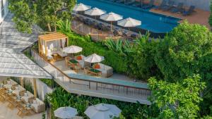 an overhead view of a resort with a pool and tables and umbrellas at Andaman Beach Hotel Phuket - Handwritten Collection in Patong Beach