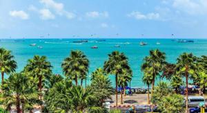 une vue sur une plage avec des palmiers et l'océan dans l'établissement OYO 1130 CK Resort Pattaya, à Nong Prue