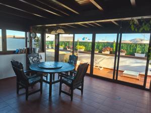 a dining room with a table and chairs and a patio at Casa Orymar in Cotillo +20 photos