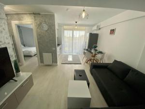 una sala de estar con un sofá y una mesa en Dis Summer Residence Mamaia, en Constanţa