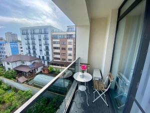 Un balcón con una mesa y sillas en un balcón. en Dis Summer Residence Mamaia, en Constanţa