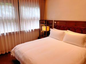 Postel nebo postele na pokoji v ubytování Jingshan Garden Hotel