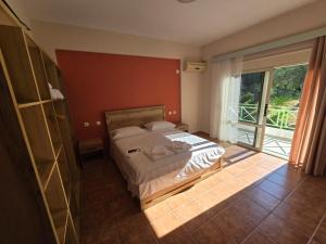 a bedroom with a bed and a large window at Olivet Hotel in Vlorë