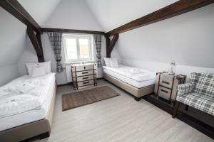 a room with two beds and a chair and a window at Apartamenty NEPTUN in Poznań